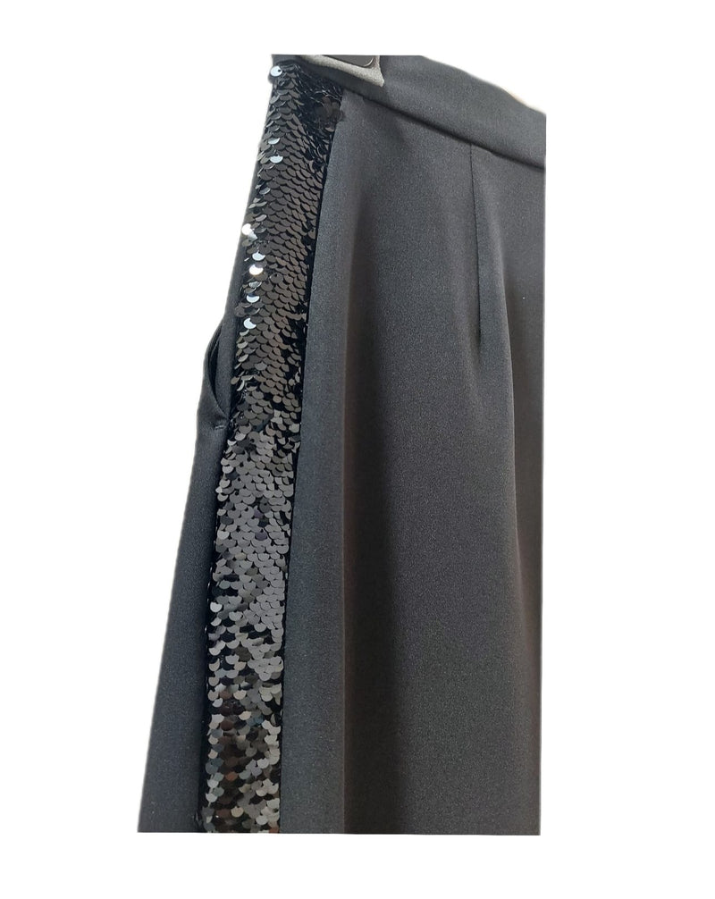 Chicchissimo pantalone a palazzo con banda laterale in paillettes nero, allacciatura con bottone e zip, vita alta, modello cropped, risvolto finale, tessuto misto viscosa.  Abbinalo in modo elegante con  un tacco e una camicia oppure rendilo più casual con una sneakers e un pullover cropped.  Collezione Autunno/Inverno Actitude Twinset 22/23.